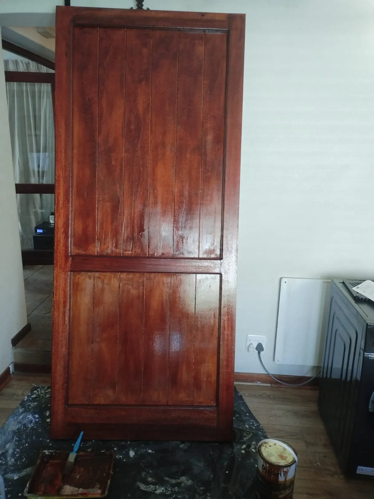 The completed barn door standing finished, showing the even stain across the framed panels