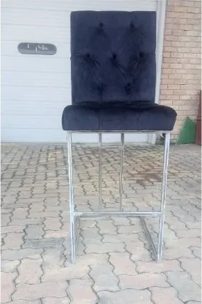 The finished upholstered bar stool from the side, showing the sled base and footrail