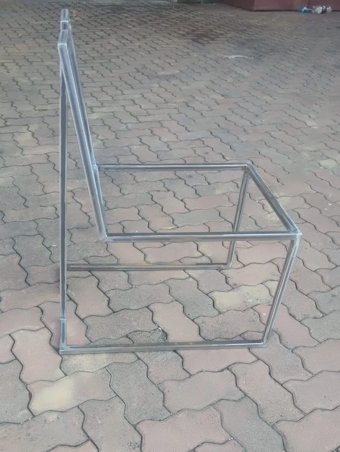 Stainless steel chair frame in a cube form, seen from the side