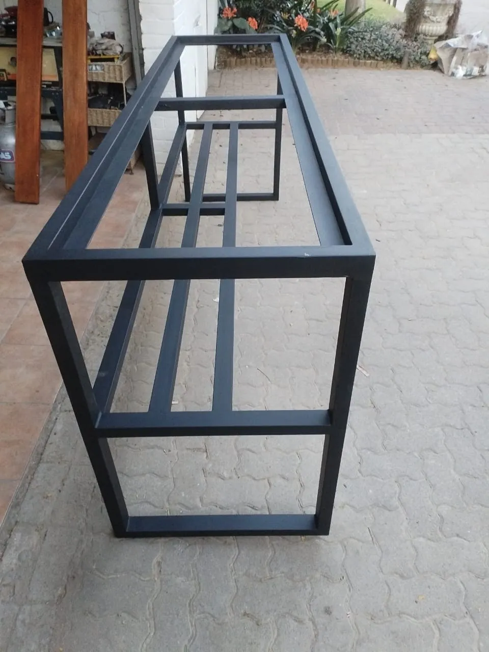 Painted console frame from the end, showing the lower stretcher rails and the slim top rebate