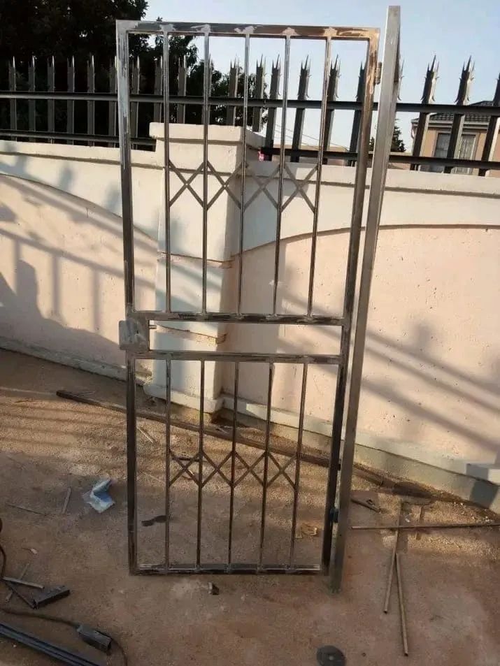 Stainless steel pedestrian gate with a diamond-pattern infill panel top and bottom