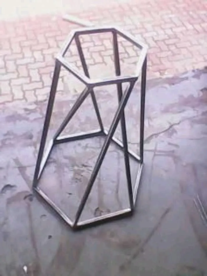 Hexagonal stainless steel side table base with faceted, tapering legs