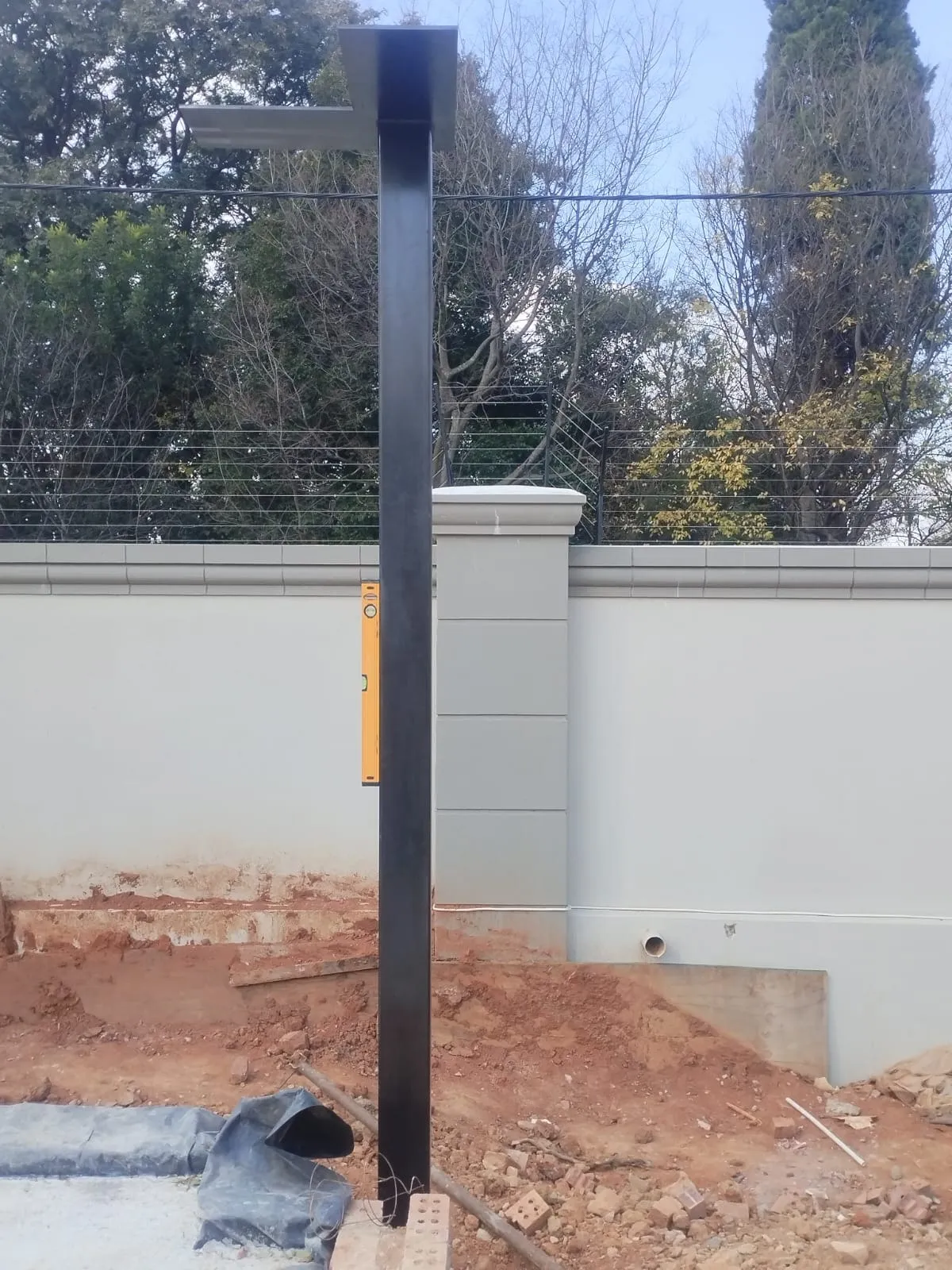 A structural steel column being checked for plumb with a spirit level